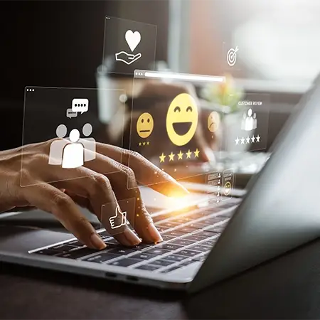 Hände tippen auf einer Laptoptastatur mit schwebenden digitalen Symbolen, darunter ein Herz, Chat-Blasen und ein Daumen nach oben. Das Bild spiegelt Kommunikation im Düsseldorfer Webdesign-Stil wider, ideal für die Entwicklung von Firmenhomepages und die Verbesserung von Unternehmenswebsites in der digitalen Landschaft.