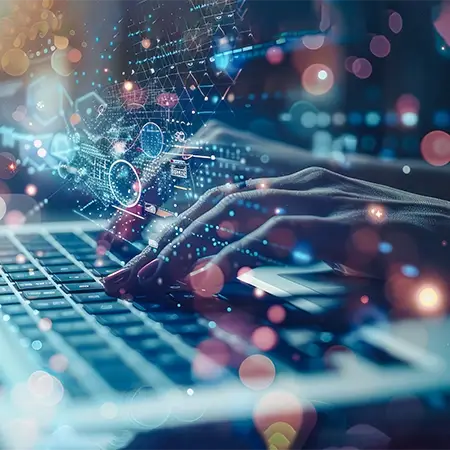 Hände tippen auf einer Laptoptastatur mit einer futuristischen Überlagerung digitaler Grafiken, darunter Datendiagramme und geometrische Formen, vor einem Hintergrund aus bunten, verschwommenen Lichtern – perfekt für Webdesign in Düsseldorf.